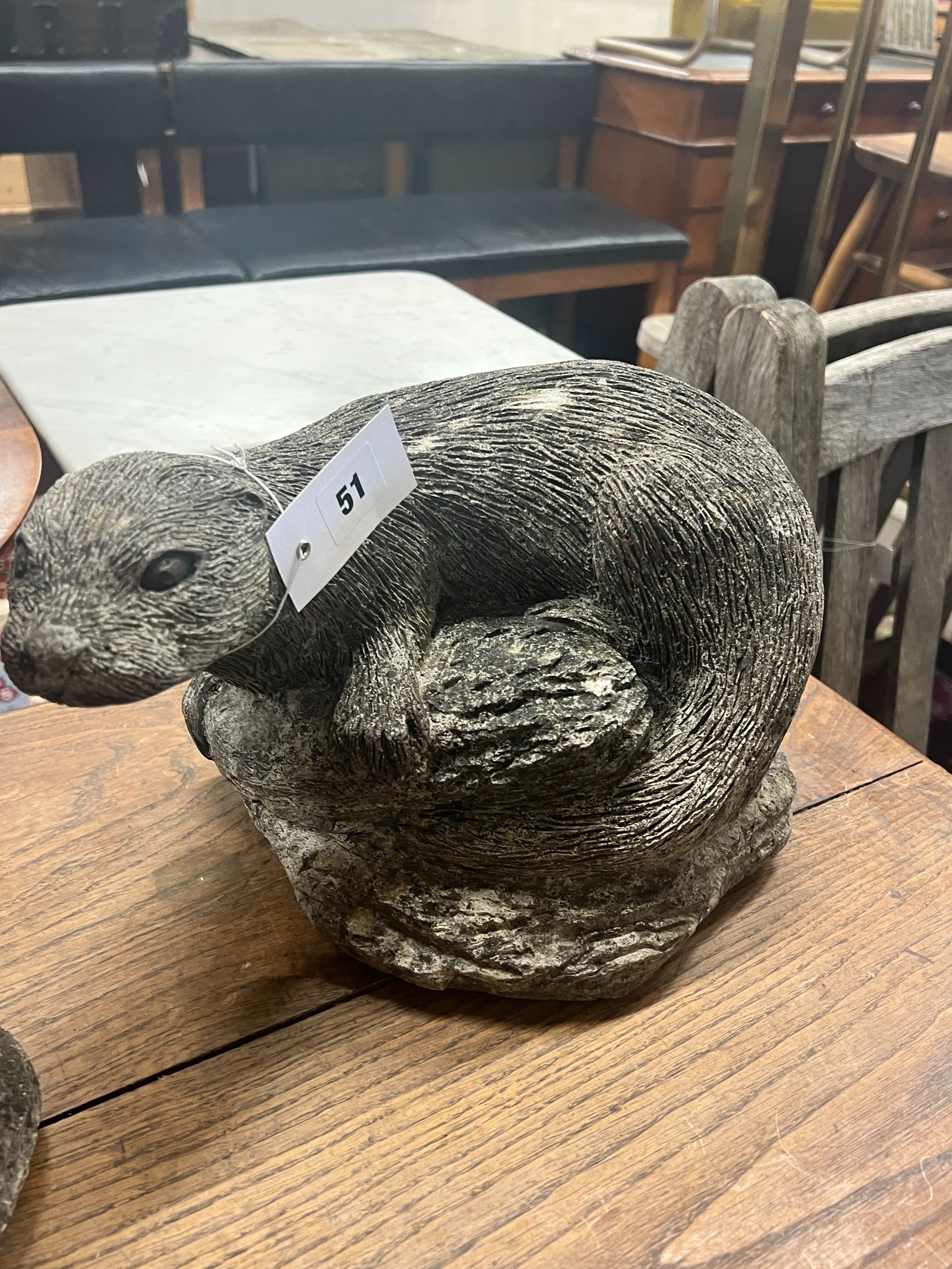 Two reconstituted stone otter garden ornaments, tallest 40cm